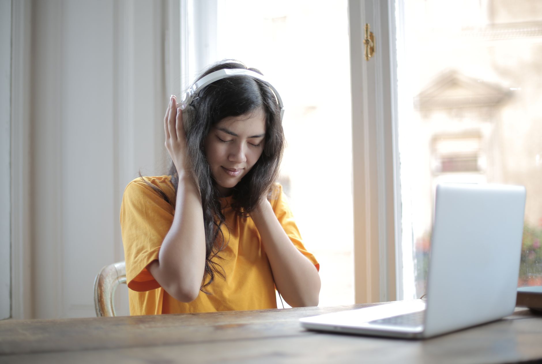 Persona joven escuchando música indie latinoamericana con audífonos, inmersa en una experiencia sonora auténtica y culturalmente rica.
