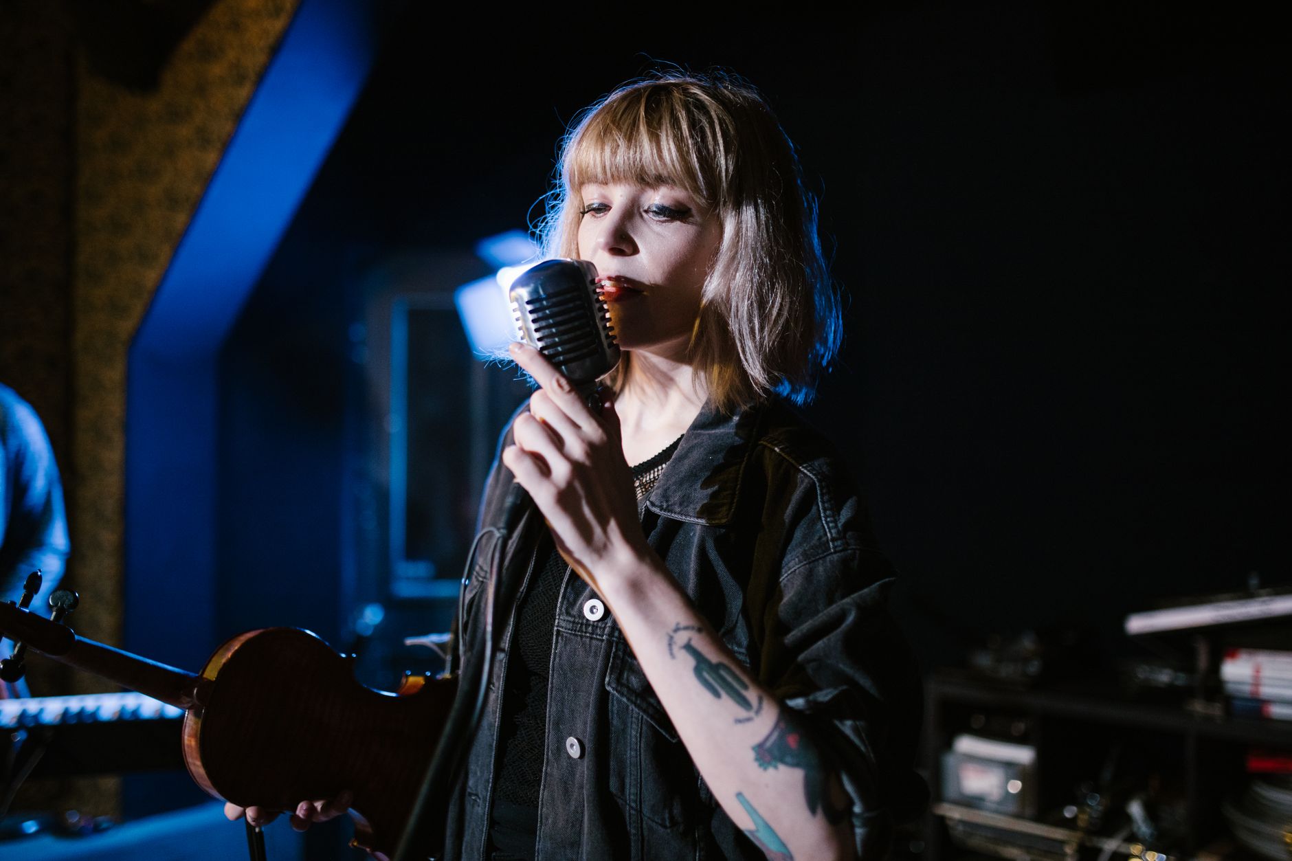 Músico contemporáneo en estudio con equipo vintage, simbolizando la influencia de los 80s y 90s en el indie actual.